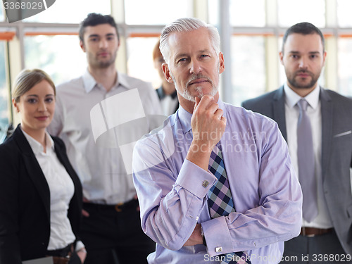 Image of senior business man with his team at office