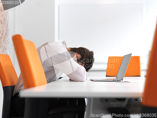 Image of frustrated young business man at office