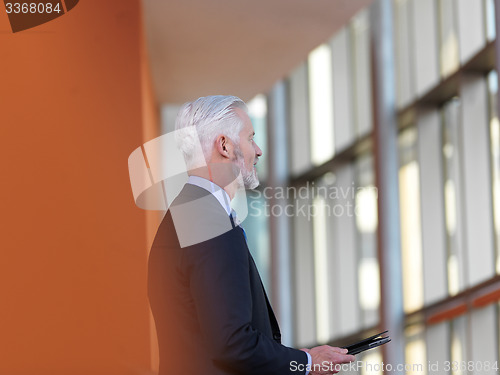 Image of senior business man working on tablet computer