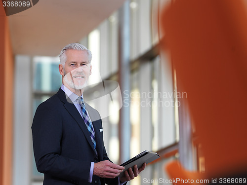 Image of senior business man working on tablet computer