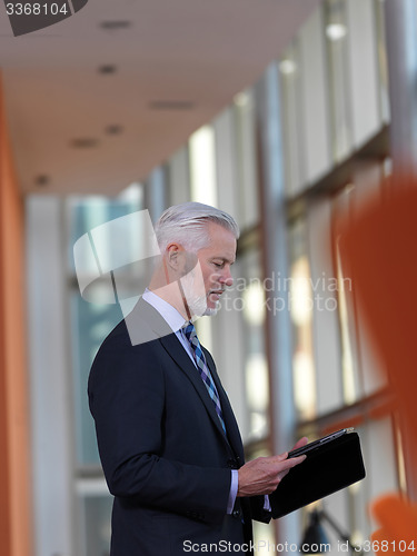 Image of senior business man working on tablet computer