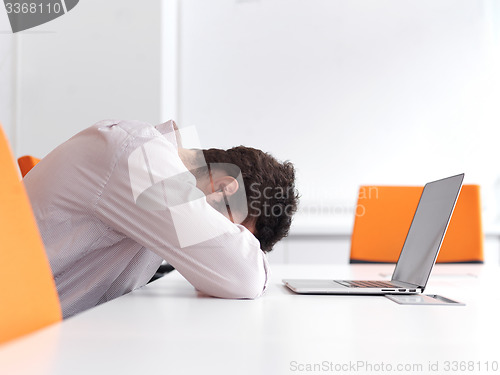 Image of frustrated young business man at office