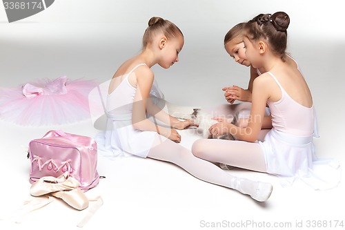 Image of Three little ballet girls sitting and posing together