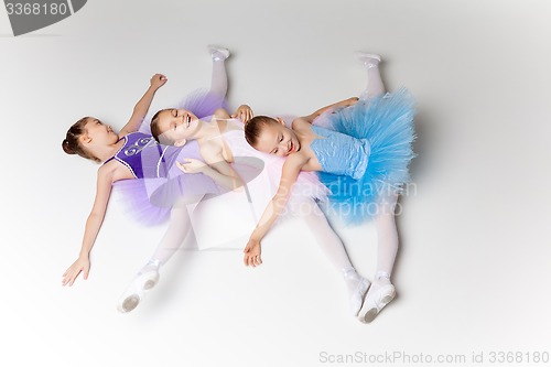 Image of Three little ballet girls in tutu lying and posing together