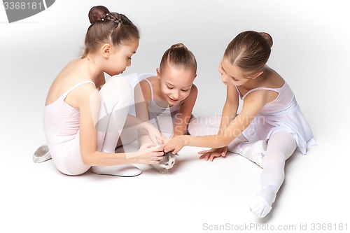 Image of Three little ballet girls sitting and posing together
