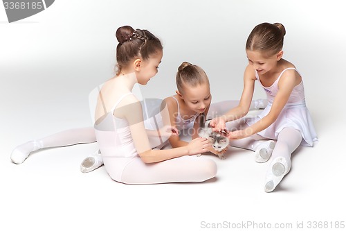 Image of Three little ballet girls sitting and posing together