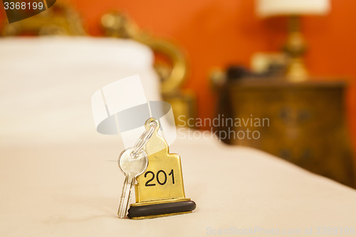 Image of Hotel Room Key lying on Bed with keyring