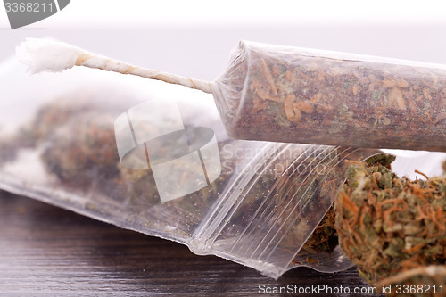 Image of Close up of dried marijuana leaves and joint