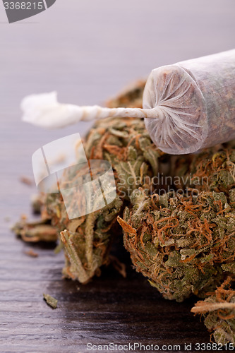 Image of Close up of dried marijuana leaves and joint