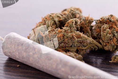 Image of Close up of dried marijuana leaves and joint