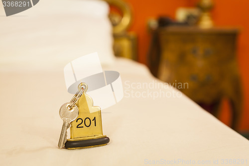 Image of Hotel Room Key lying on Bed with keyring