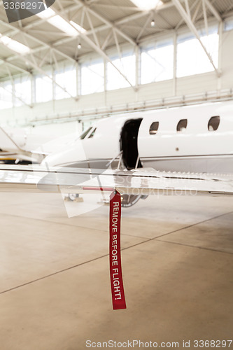 Image of Airplane in Hangar with remove before flight Labels in red