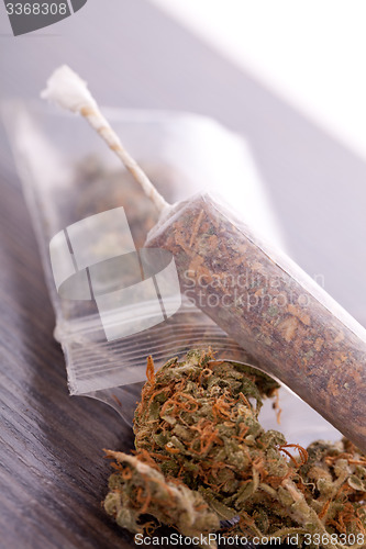 Image of Close up of dried marijuana leaves and joint