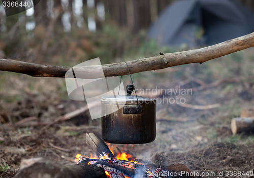 Image of Cooking in sooty cauldron on campfire