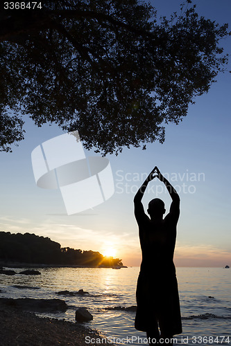 Image of Man on coast saluting sun 