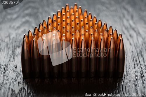 Image of Macro shot of copper bullets that are in many rows to form a tri