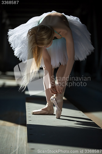 Image of Dancer tying pointe shoes