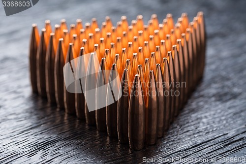 Image of Macro shot of copper bullets that are in many rows to form a tri