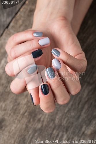 Image of Beautiful hands with the miniature painted in a gray-colored nai