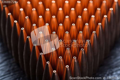 Image of Macro shot of copper bullets that are in many rows to form a tri