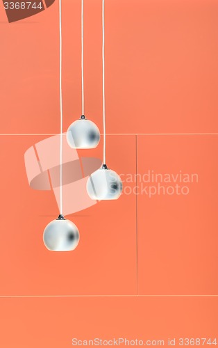 Image of Orange negative collage of three ceiling lights, loft-style inte