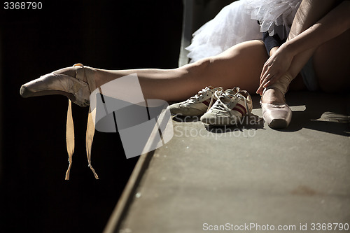 Image of Ballerina sitting on the edge of bridge