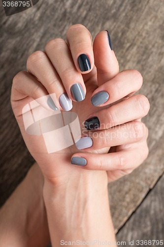 Image of Beautiful hands with the miniature painted in a gray-colored nai