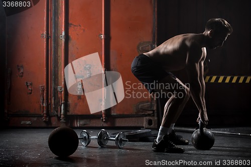 Image of Beautiful athlete doing kettlebell swings