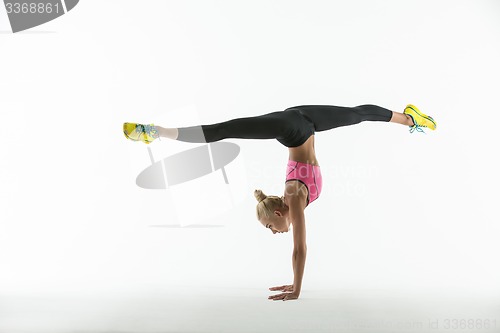 Image of Rhythmic gymnast doing exercise in studio.