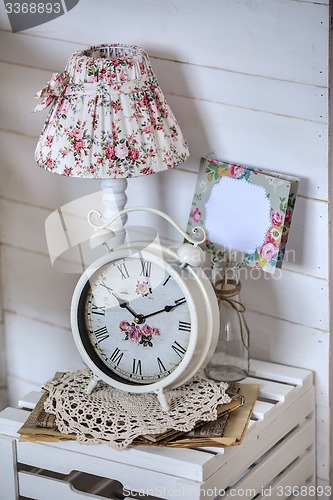 Image of Bedside table with lamp and alarm clock