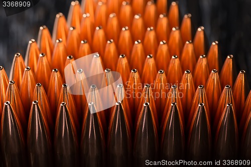 Image of Macro shot of copper bullets that are in many rows to form a tri