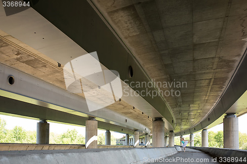 Image of Graceful ballerina doing dance exercises on a concrete bridge 