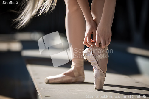 Image of Dancer tying pointe shoes