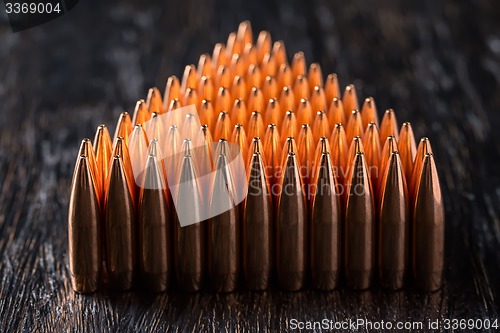 Image of Macro shot of copper bullets that are in many rows to form a tri