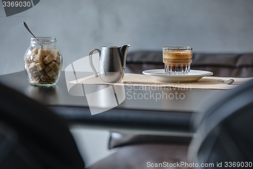 Image of Coffee espresso on black glossy table.