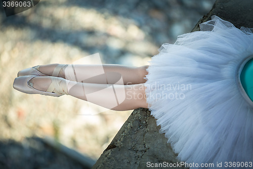 Image of Ballerina sitting on the edge of bridge