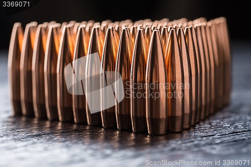 Image of Macro shot of copper bullets that are in many rows to form a tri