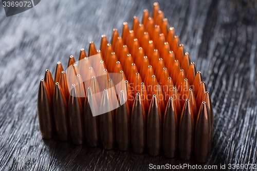 Image of Macro shot of copper bullets that are in many rows to form a tri