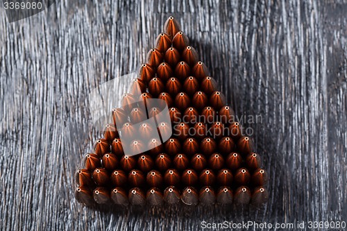 Image of Macro shot of copper bullets that are in many rows to form a tri