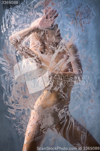 Image of Portrait of seminude blonde through the glass smeared pink clay