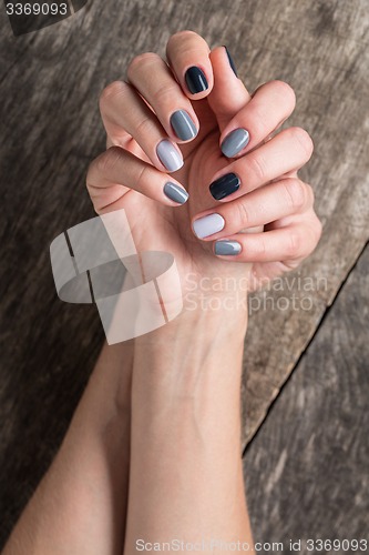 Image of Beautiful hands with the miniature painted in a gray-colored nai