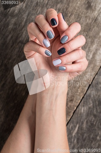 Image of Beautiful hands with the miniature painted in a gray-colored nai