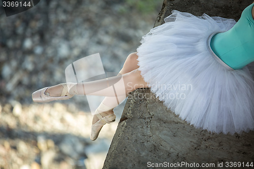 Image of Ballerina sitting on the edge of bridge