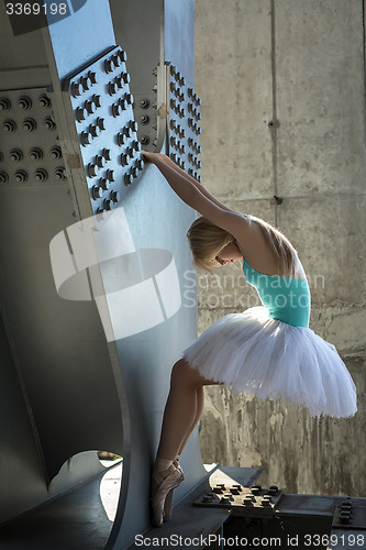 Image of Graceful ballerina in the industrial background