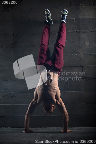 Image of Athlete with naked torso doing push-ups on his hands