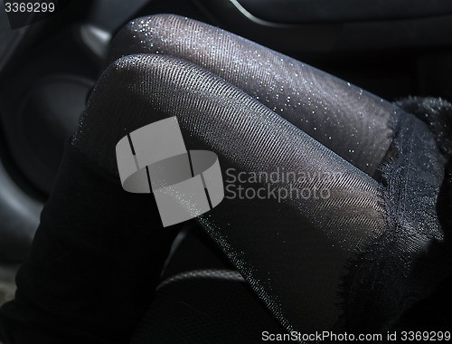 Image of Slender sexy legs in shiny pantyhose in car