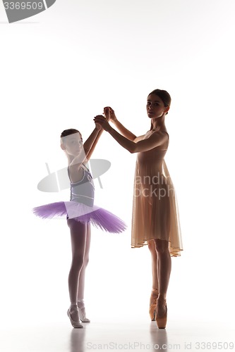 Image of The little ballerina dancing with personal ballet teacher in dance studio