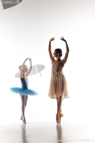 Image of The little ballerina dancing with personal ballet teacher in dance studio