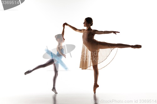 Image of The little ballerina dancing with personal ballet teacher in dance studio