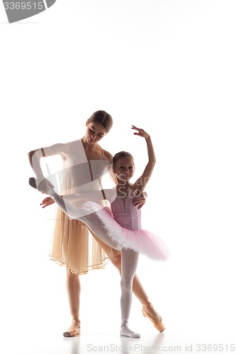 Image of The little ballerina dancing with personal ballet teacher in dance studio